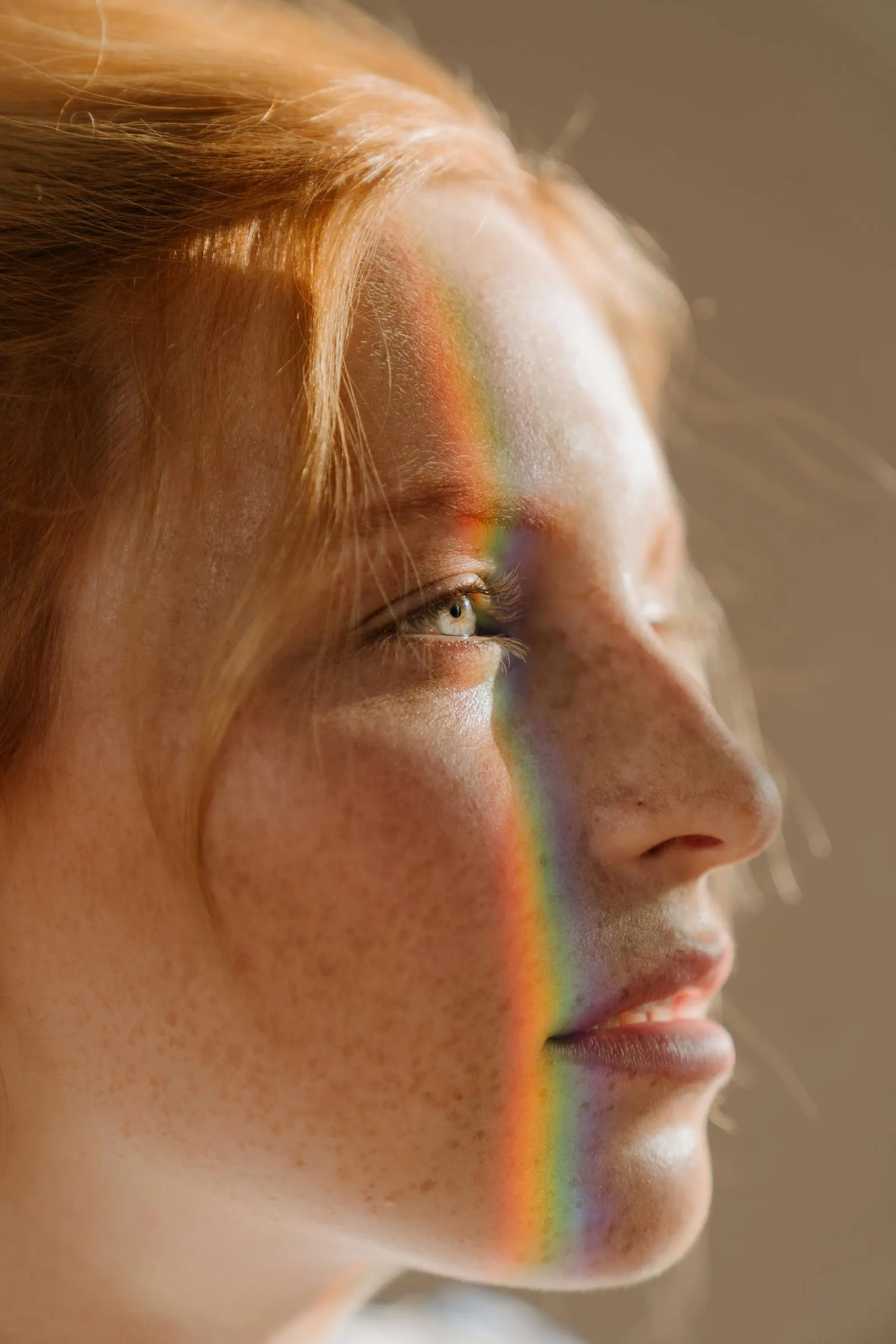 A woman with a rainbow reflex on her face.
